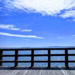 bright blue sky with a wooden bridge over the ocean