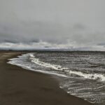 stormy day at the beach, waves and clouds threatening